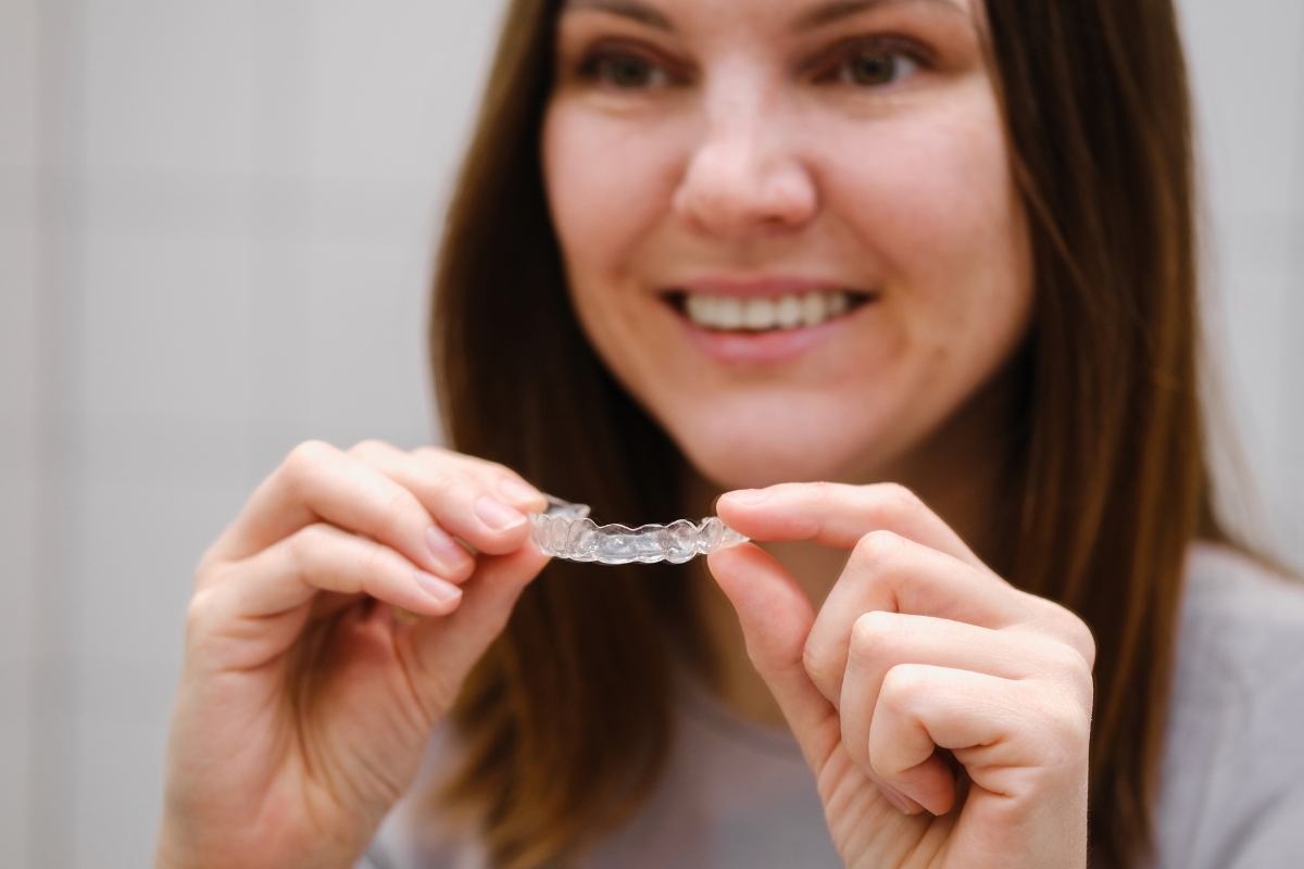 Person holding a night guard for teeth in Highlands Ranch, demonstrating its use for teeth grinding protection
